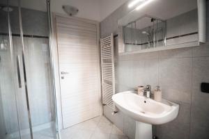 a bathroom with a sink and a shower and a mirror at Alpine Green Apartment 2026 in Sondrio