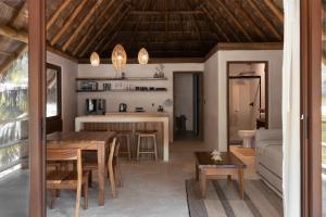 a kitchen and living room with a table and a couch at Hábitat Nandá in La Manzanilla