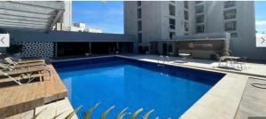 a large blue swimming pool on top of a building at Crystal Place Flat 509 in Goiânia