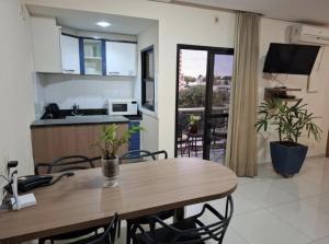 a kitchen and dining room with a wooden table and chairs at Crystal Place Flat 509 in Goiânia