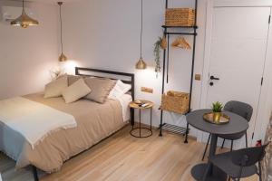 a bedroom with a bed and a table and a door at Ca l'Eli Loft in Montblanc