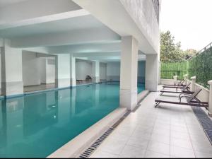 a swimming pool with blue water in a building at Skyline Luxury 17th-Floor 1BR near Junction Mall - City Views, Pool, Gym & Full-Body Massage Chair in Nairobi