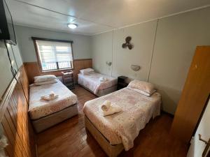 a room with two beds with towels on them at HOSTAL VICTORIA in Punta Arenas