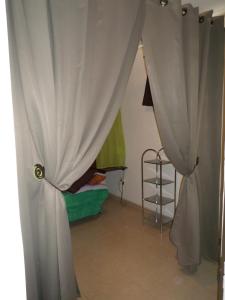 a room with curtains and a bed and a table at Tropical holidays at Frantz in Port-Louis +4 photos