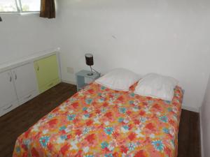 a bedroom with a bed with a colorful blanket and pillows at Tropical holidays at Frantz in Port-Louis