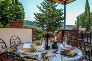 a table with plates and wine glasses on a patio at Agriturismo Dandelion in Città della Pieve