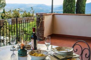 a table with a bottle of wine and wine glasses at Agriturismo Dandelion in Città della Pieve