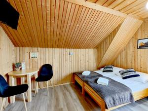 a bedroom with a bed and a table and chairs at Noclegi Sarenka in Murzasichle
