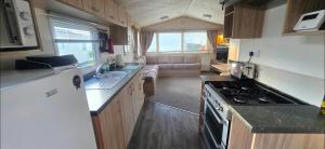 a kitchen with a sink and a stove top oven at Vanhalla in Heysham