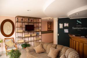 a living room with a couch and a shelf at Hotel Santamaria INN in La Ceja