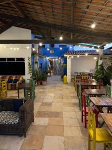 a restaurant with wooden tables and chairs and a large room at Casa da Juma in Fortim