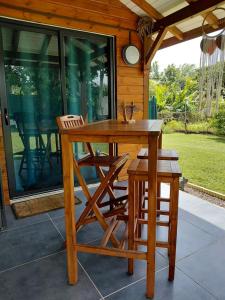 a wooden table and chairs on a patio at Bungalow Capucine in Capesterre-Belle-Eau