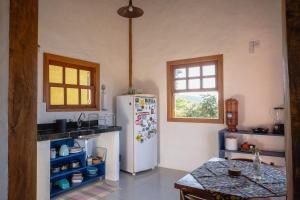 a kitchen with a refrigerator and a table at Milho Ventura II, Vila Pôr do Sol in Sêrro +14 photos