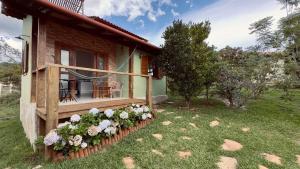 a house with a porch with flowers on it at Milho Ventura II, Vila Pôr do Sol in Sêrro