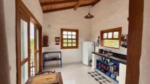 a kitchen with a refrigerator and a table in it at Milho Ventura II, Vila Pôr do Sol in Sêrro