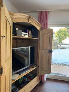 an open wooden cabinet with a television in it at Allgäutraum in Bolsterlang +9 photos
