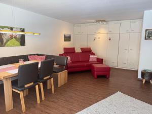 a living room with a red couch and a table at Allgäutraum in Bolsterlang