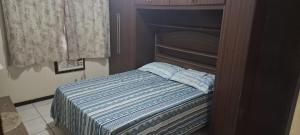 a small bed in a room with a curtain at Casa Ampla Vila Muriqui in Vila Muriqui +25 photos