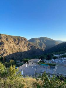 a view of a town with mountains in the background at Los Albergues in Pitres