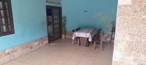 a table and chairs in a room with a blue wall at Casa Ampla Vila Muriqui in Vila Muriqui