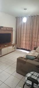 a living room with a bed and a flat screen tv at Casa Ampla Vila Muriqui in Vila Muriqui