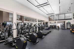 a gym with a large room with rows of tread machines at Prime Downtown Miami Location with Rooftop Pool in Miami