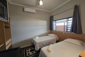 a small room with two beds and a window at Zuccaro Studio in Bauru +78 photos