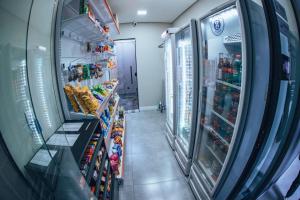 a grocery store aisle with drinks and food at Zuccaro Studio in Bauru