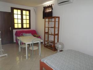 a room with a table and chairs and a room with a bed at Villa Barboteau in Port-Louis