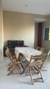 a wooden table and chairs in a room with a couch at Dunas Exclusive in Santo Amaro