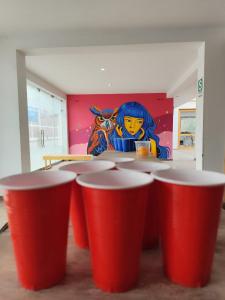 a group of red cups in a room with a painting at Shambala Hostel in Huacachina