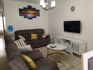 a living room with a couch and a tv at Unity Homes Eldoret in Eldoret
