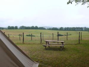 une table de pique-nique dans un champ à côté d'une clôture dans l'établissement Alpagas du Quercy, à Frayssinet