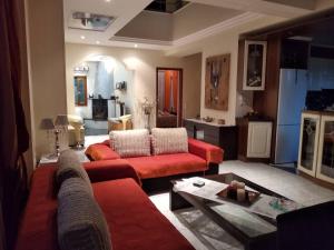 a living room with two red couches and a table at Villa Evi in Volos