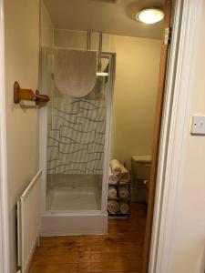a glass shower in a bathroom with a toilet at Derbyshire Holiday Cottages in Holmesfield