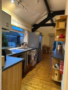 a kitchen with a refrigerator and a stove top oven at Derbyshire Holiday Cottages in Holmesfield