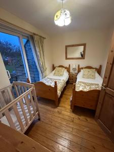 two beds in a room with a window at Derbyshire Holiday Cottages in Holmesfield