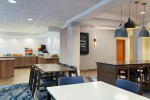 a restaurant with tables and chairs and a counter at Fairfield Inn & Suites by Marriott Edison - South Plainfield in Edison