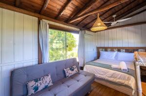 a living room with a couch and a bed at Pousada Watu Kerere in Praia do Rosa +186 photos