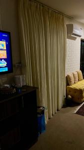 a living room with a couch and a television at Lozi House Cozy Stay in Al Azraq ash Shamālī