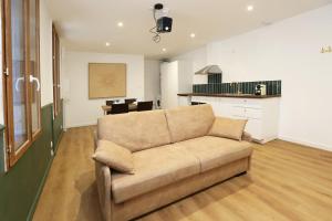 a living room with a couch and a kitchen at Superbe appartement avec écran géant in Tarbes