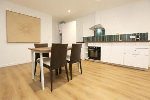 a kitchen with a dining room table and chairs at Superbe appartement avec écran géant in Tarbes +9 photos