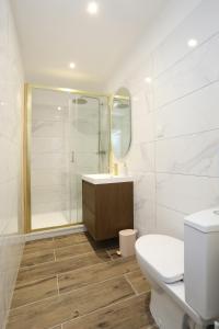 a white bathroom with a toilet and a sink at Superbe appartement avec écran géant in Tarbes