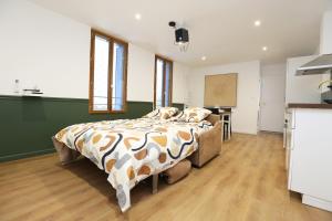 a bedroom with a bed in a room with a kitchen at Superbe appartement avec écran géant in Tarbes