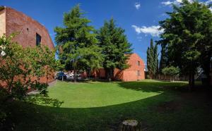 a green yard with trees and two brick buildings at Charming Suite Pool AC Location 10C in San Pablo