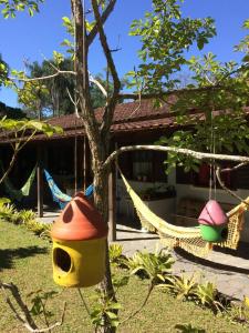 a hammock hanging from a tree in front of a house at Pousada do Campo in Ipiabas