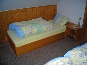 a bedroom with a bed with a wooden headboard at Ferienhaus Inge in Ilmenau