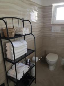 a bathroom with a rack of towels and a toilet at Bed and relax in Serre