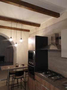 a kitchen with a stove and a table with chairs at Bed and relax in Serre