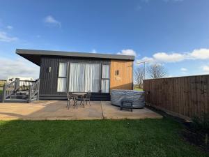 a small house with a patio with a table and chairs at The paddocks in Wisbech